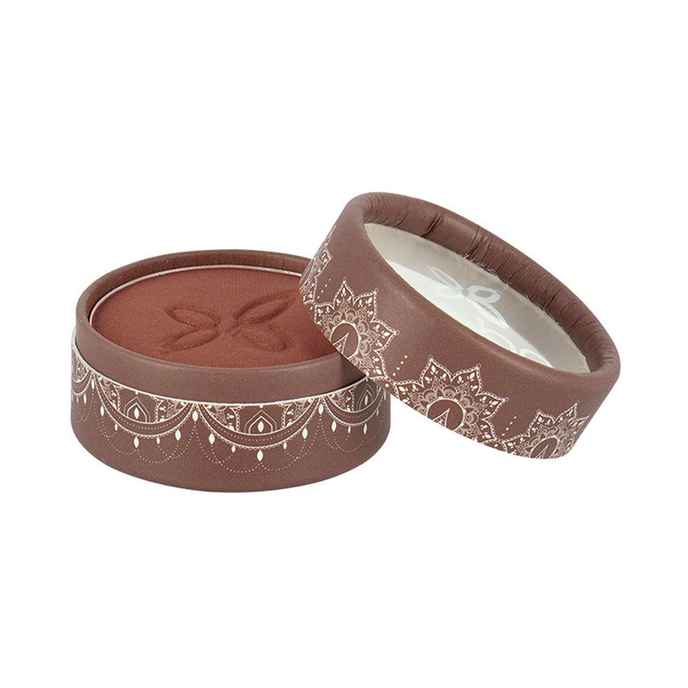 Boîte ronde marron avec couvercle. Couvercle et boîte décorés de motifs blancs. Fard à paupières marron. Couvercle ouvert.