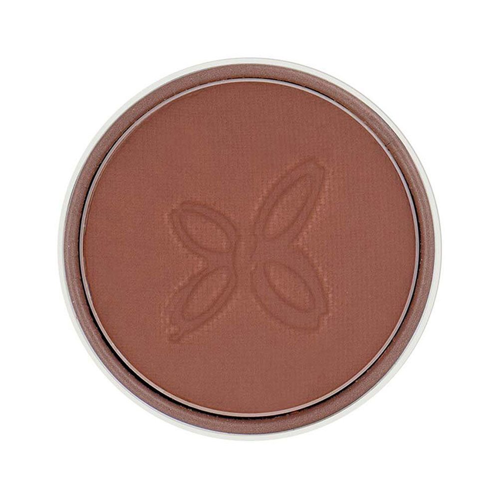 Fard à paupières rond et brun dans un contenant blanc. Un motif en relief est visible sur la surface.