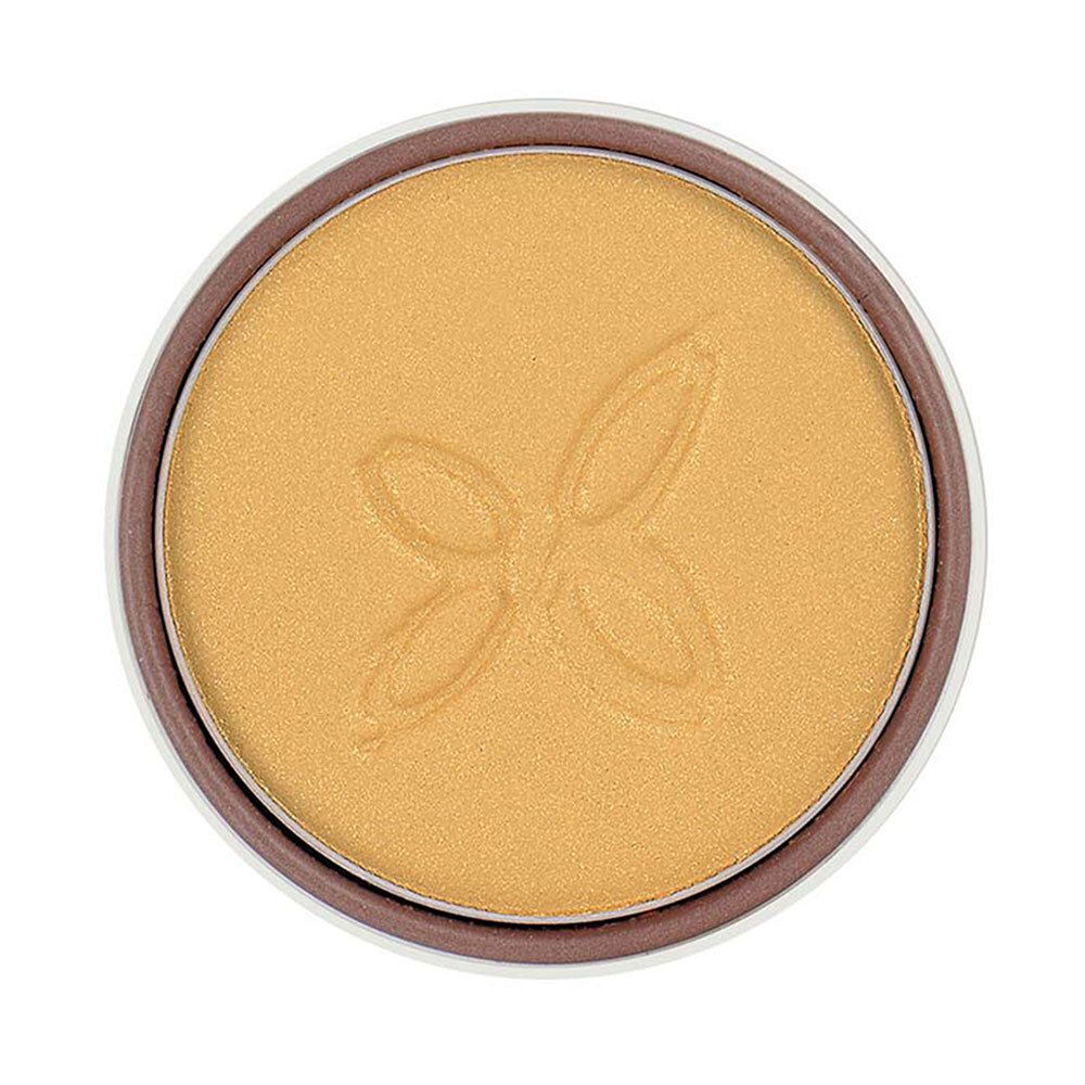 Fard à paupières doré dans un boîtier rond. Surface avec motif en relief. Bord marron.