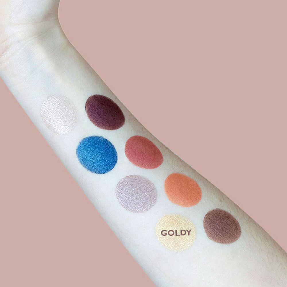 Bras avec échantillons de fards à paupières. Teinte Goldy marquée. Différentes teintes en cercles.