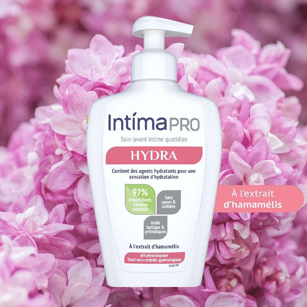 Flacon IntimaPRO HYDRA devant fleurs roses. Contient 97% ingrédients naturels, sans savon & sulfates, avec extrait d'hamamélis.