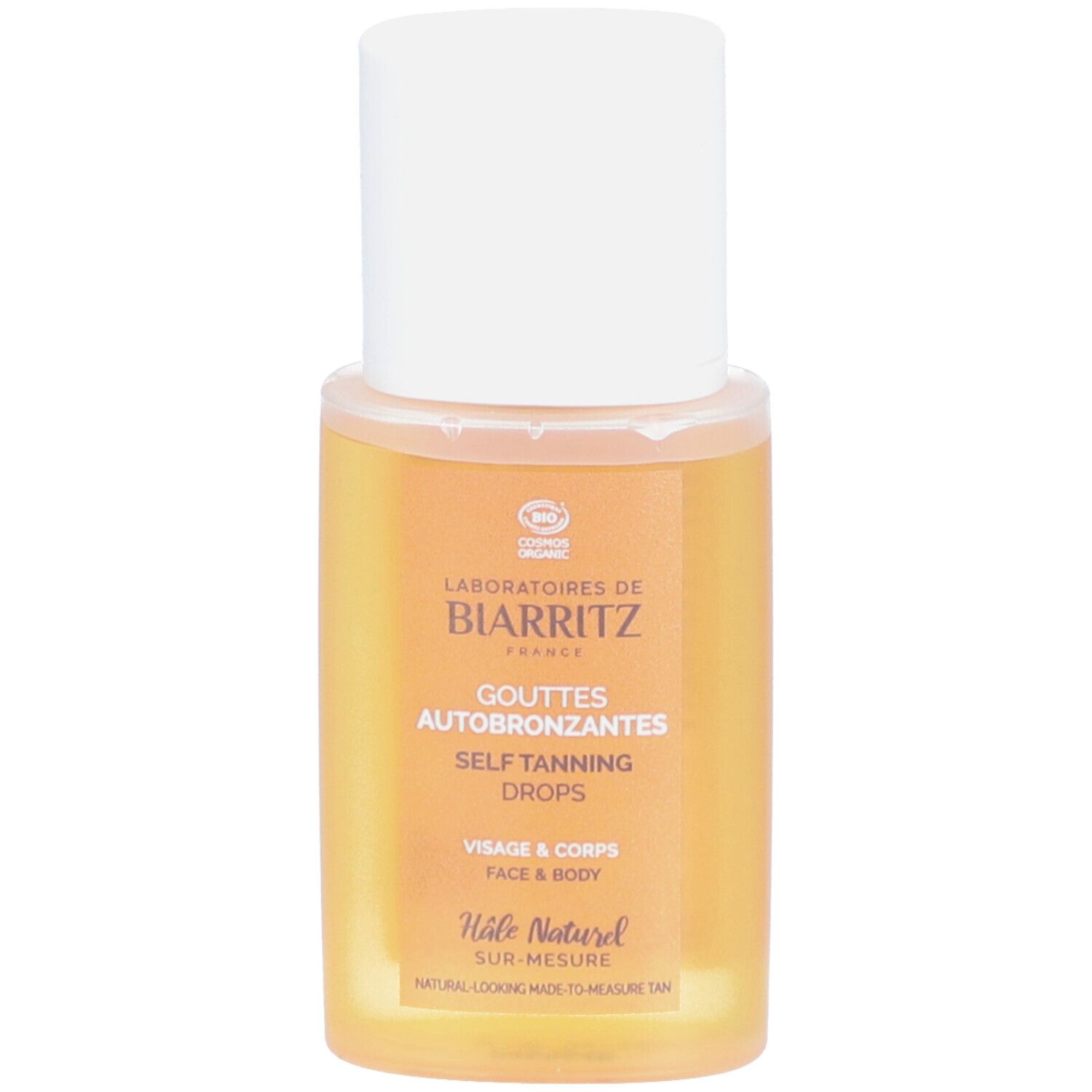 Flacon transparent avec bouchon blanc. Étiquette: LABORATOIRES DE BIARRITZ, Gouttes Autobronzantes, Visage & Corps.
