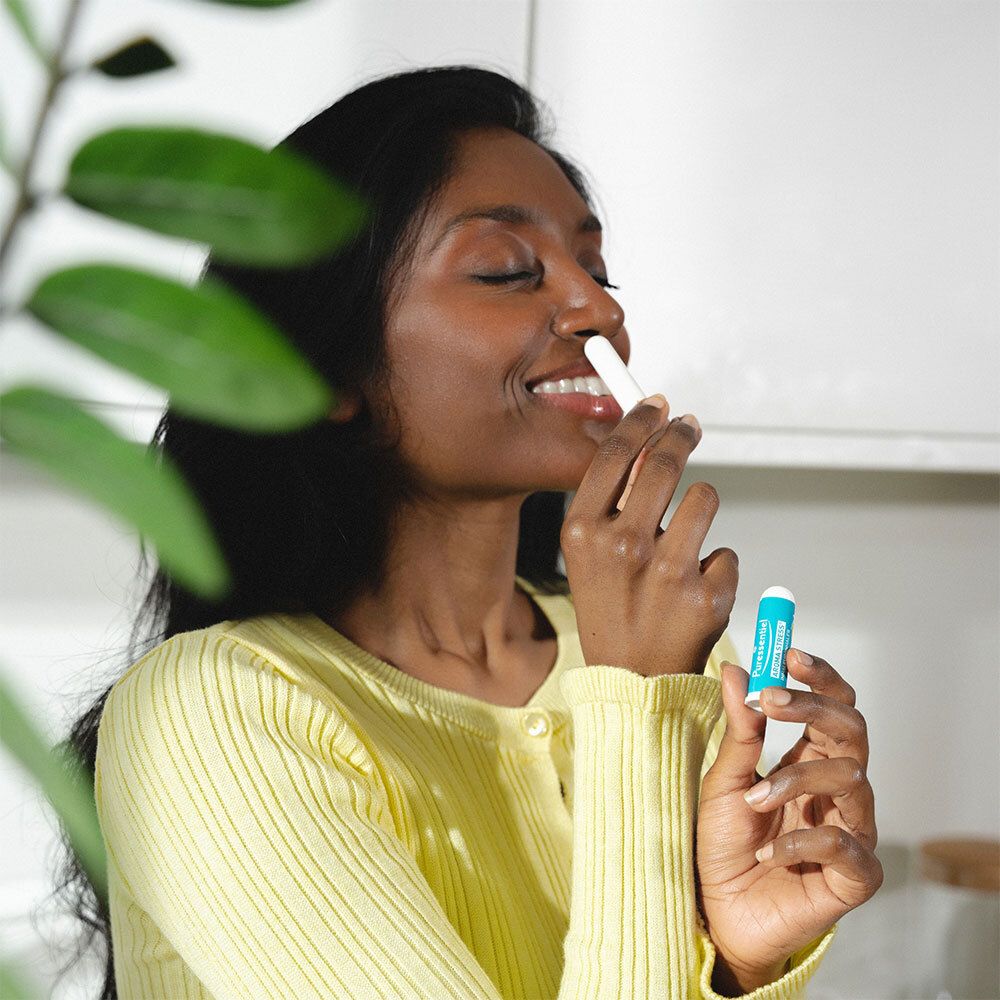 Une femme utilise un inhalateur Puressentiel AROMA STRESS®. Inscription : AROMA STRESS® Inhaler/Inhalateur.