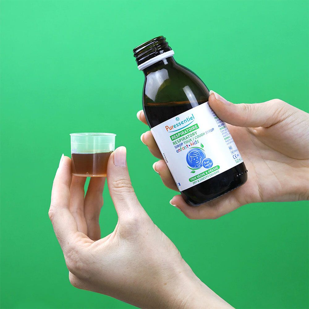 Mains tenant un flacon de sirop et un gobelet doseur. Inscription: RESPIRATOIRE SIROP TOUX ENFANT.