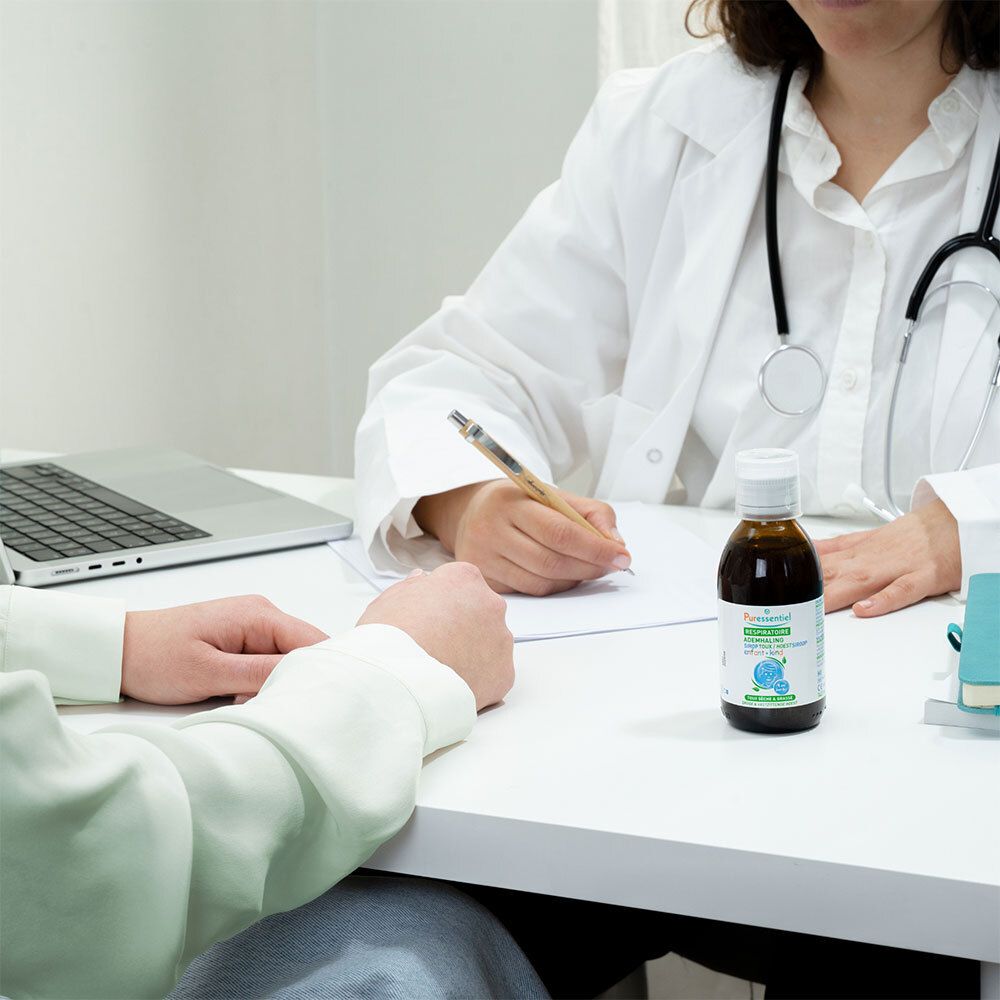 Médecin et patient avec flacon de sirop. Inscription: RESPIRATOIRE SIROP TOUX ENFANT. Sur la table.