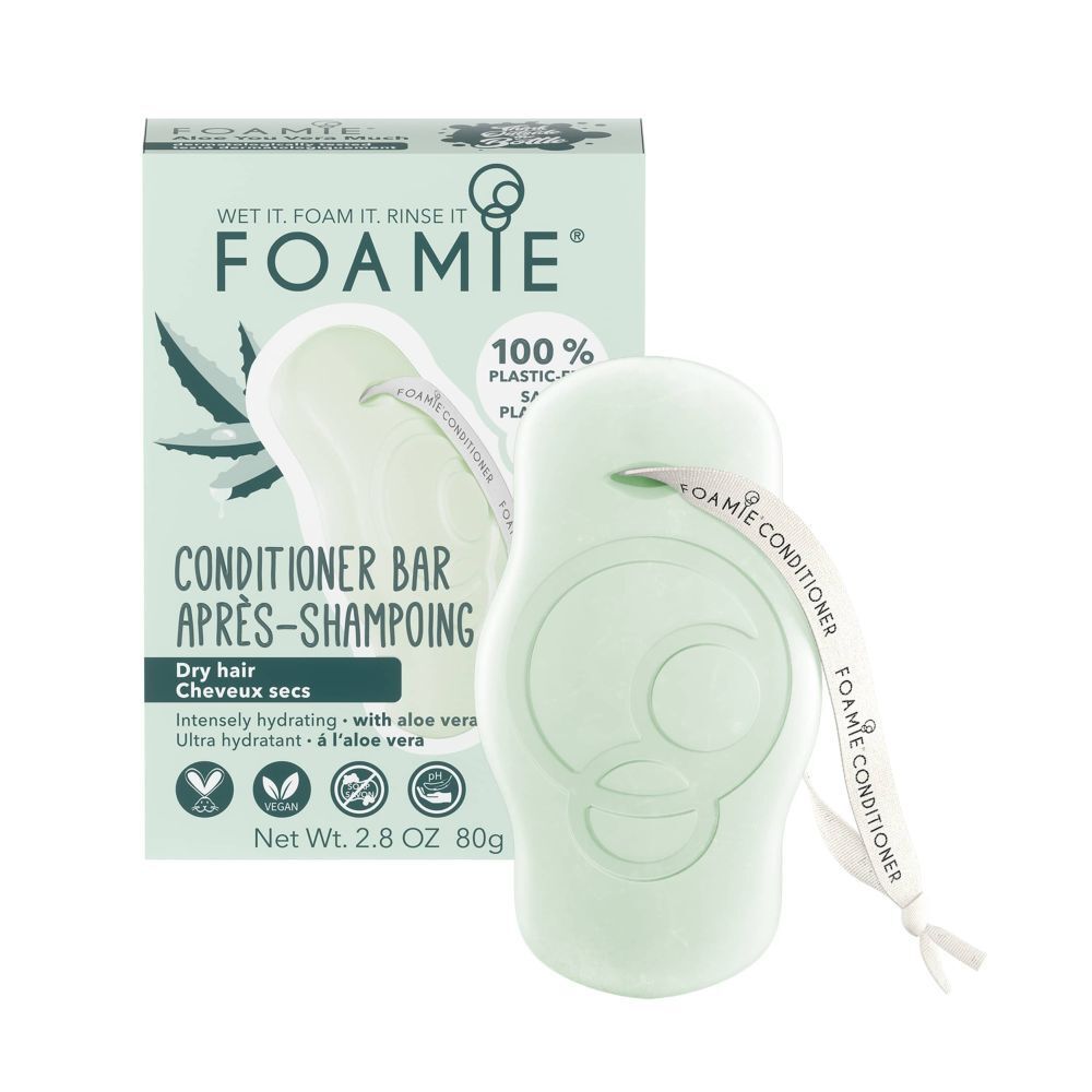 Barre après-shampooing verte avec ruban, à côté de l'emballage. Inscription : FOAMIE, Conditioner Bar, Après-Shampoing, avec Aloe Vera.