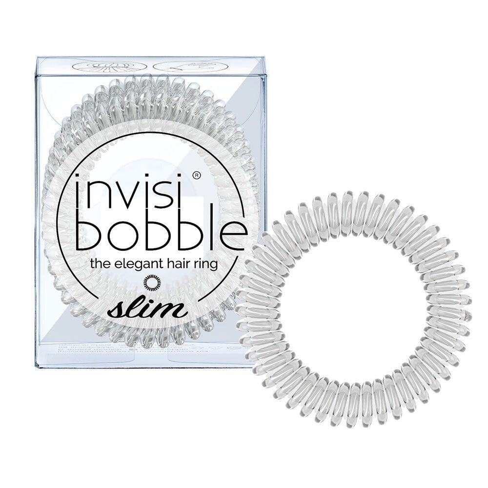 Élastique à cheveux transparent à côté d'un emballage transparent. L'emballage porte la mention "invisibobble® SLIM Kristallklar".