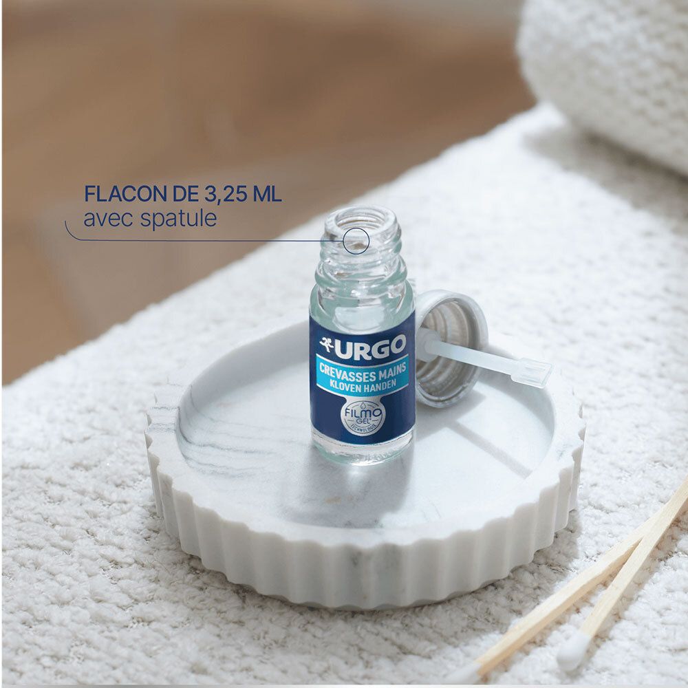 Flacon URGO Crevasses Mains avec applicateur sur plateau. Texte: FLACON DE 3,25 ML avec spatule.