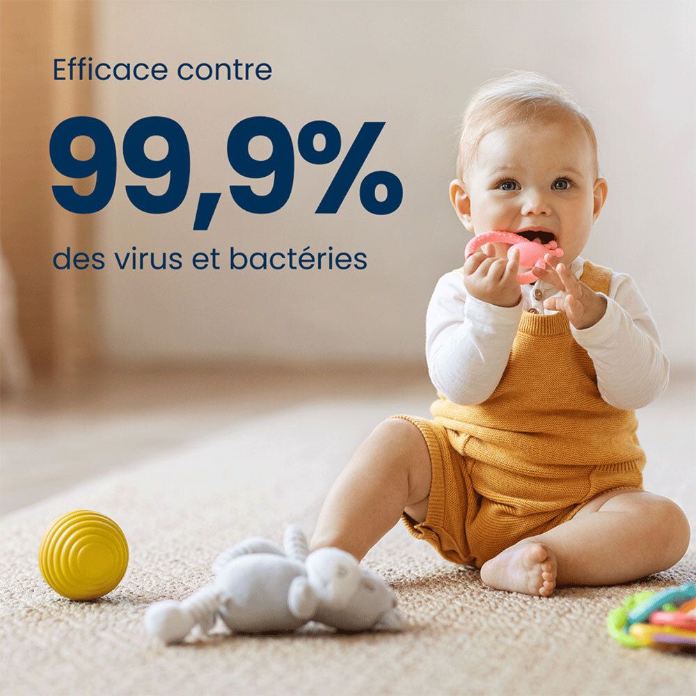 Bébé joue au sol. Texte: Efficace contre 99,9% des virus et bactéries. Bébé tient un jouet dans la bouche.