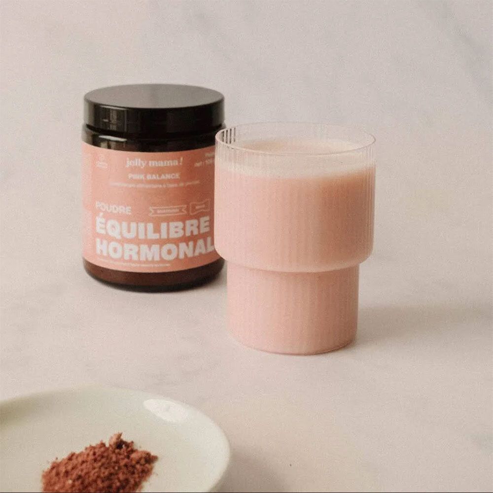 Pot JOLLY MAMA Pink Balance et verre de liquide rose. Sur une assiette: poudre rose. Texte: ÉQUILIBRE HORMONAL.