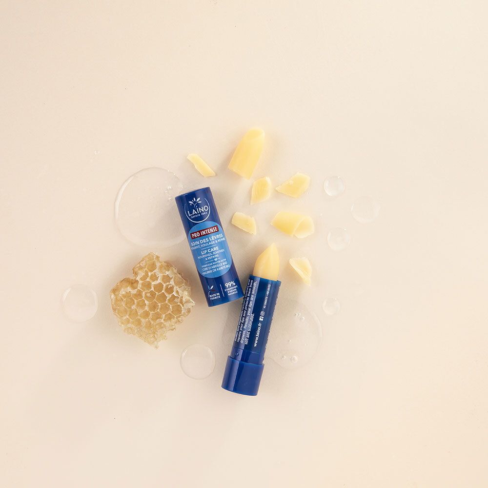 Deux sticks à lèvres bleus et rayons de miel sur fond beige. Un stick ouvert. Texte: LAINO, PRO INTENSE, LIP CARE.
