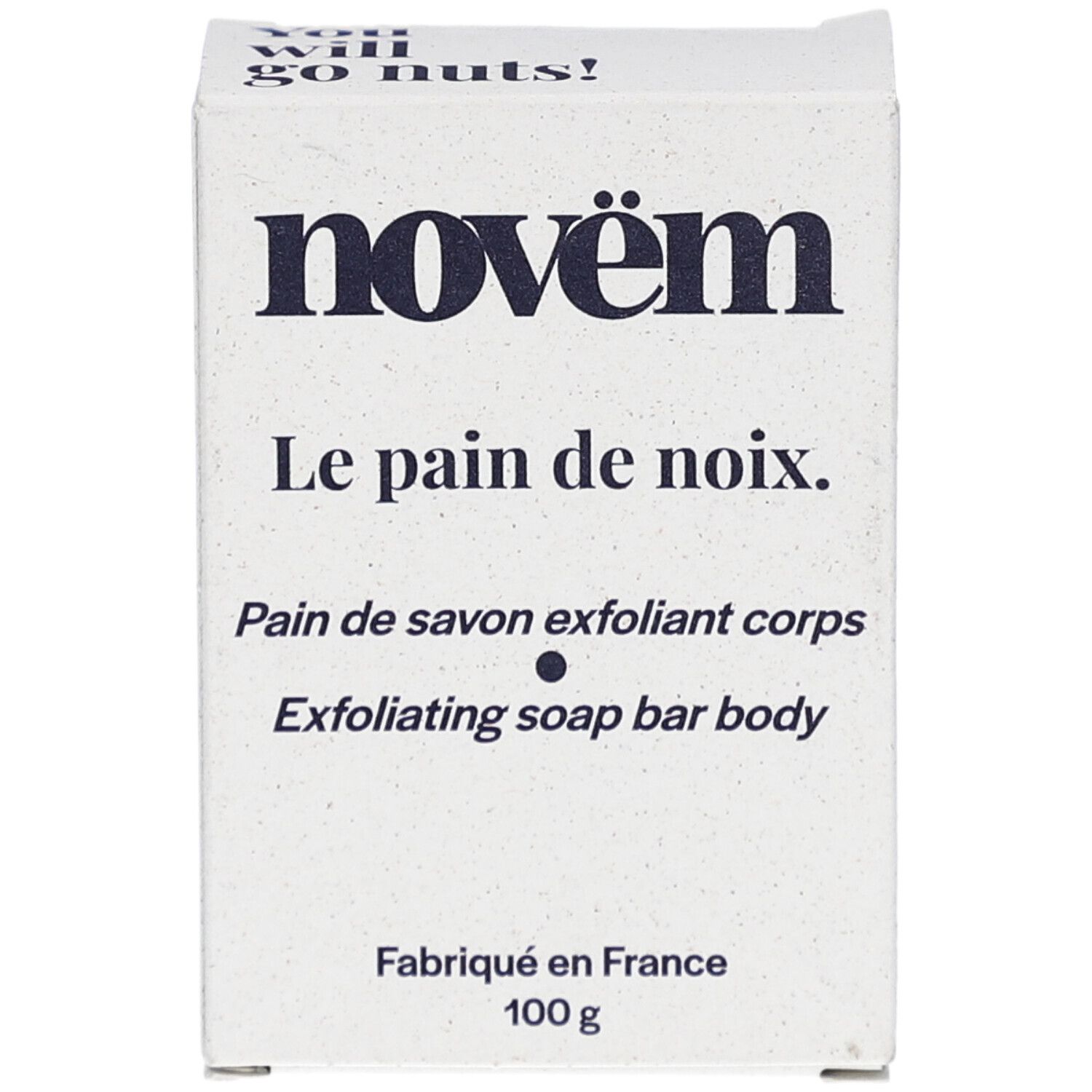 Boîte en carton blanche. Inscriptions: novëm, Le pain de noix, Pain de savon exfoliant corps, Exfoliating soap bar body. Fabriqué en France, 100 g.