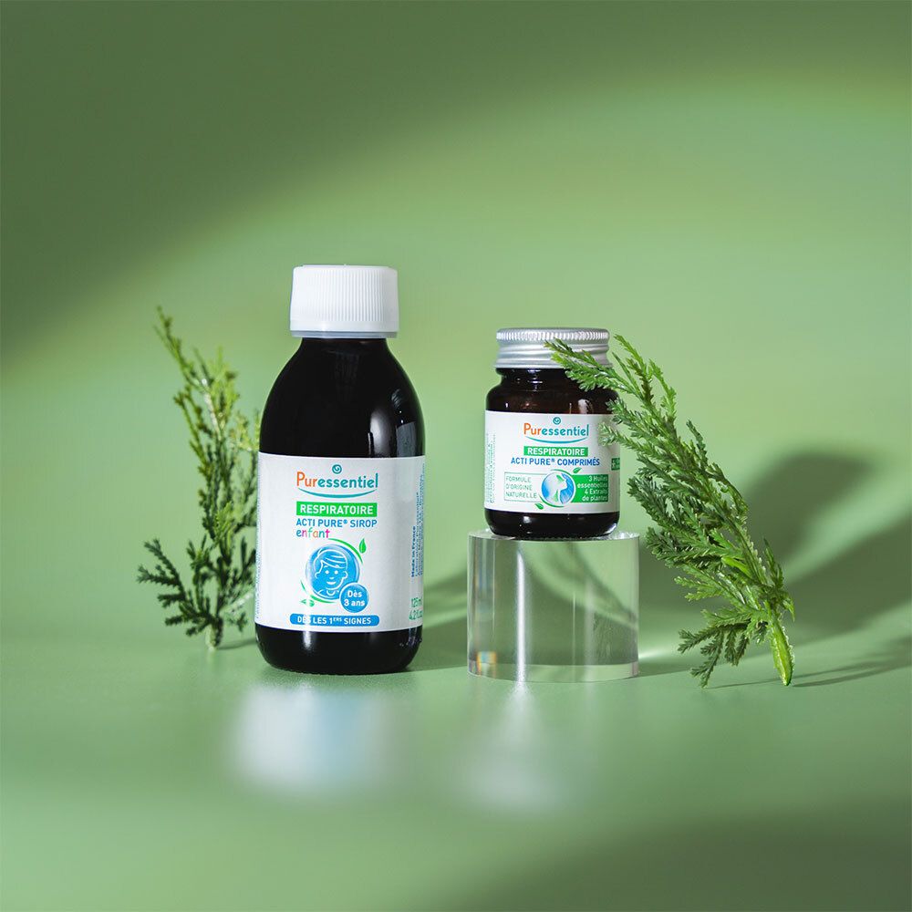 Deux flacons sur un socle. Inscription: Puresentiel Acti Pure. Fond vert avec des branches.