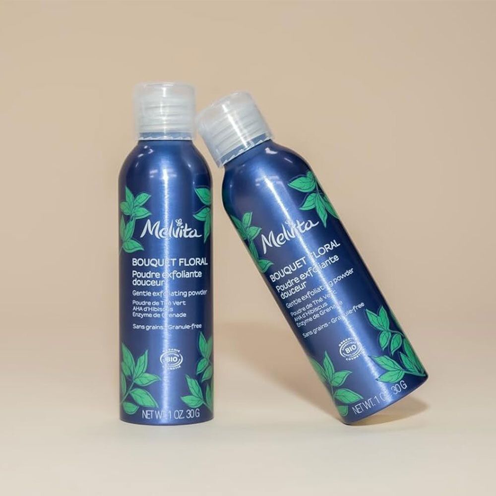 Deux flacons bleus à bouchon blanc. Inscription: Melvita, Bouquet Floral, Poudre exfoliante douceur. Certification bio.
