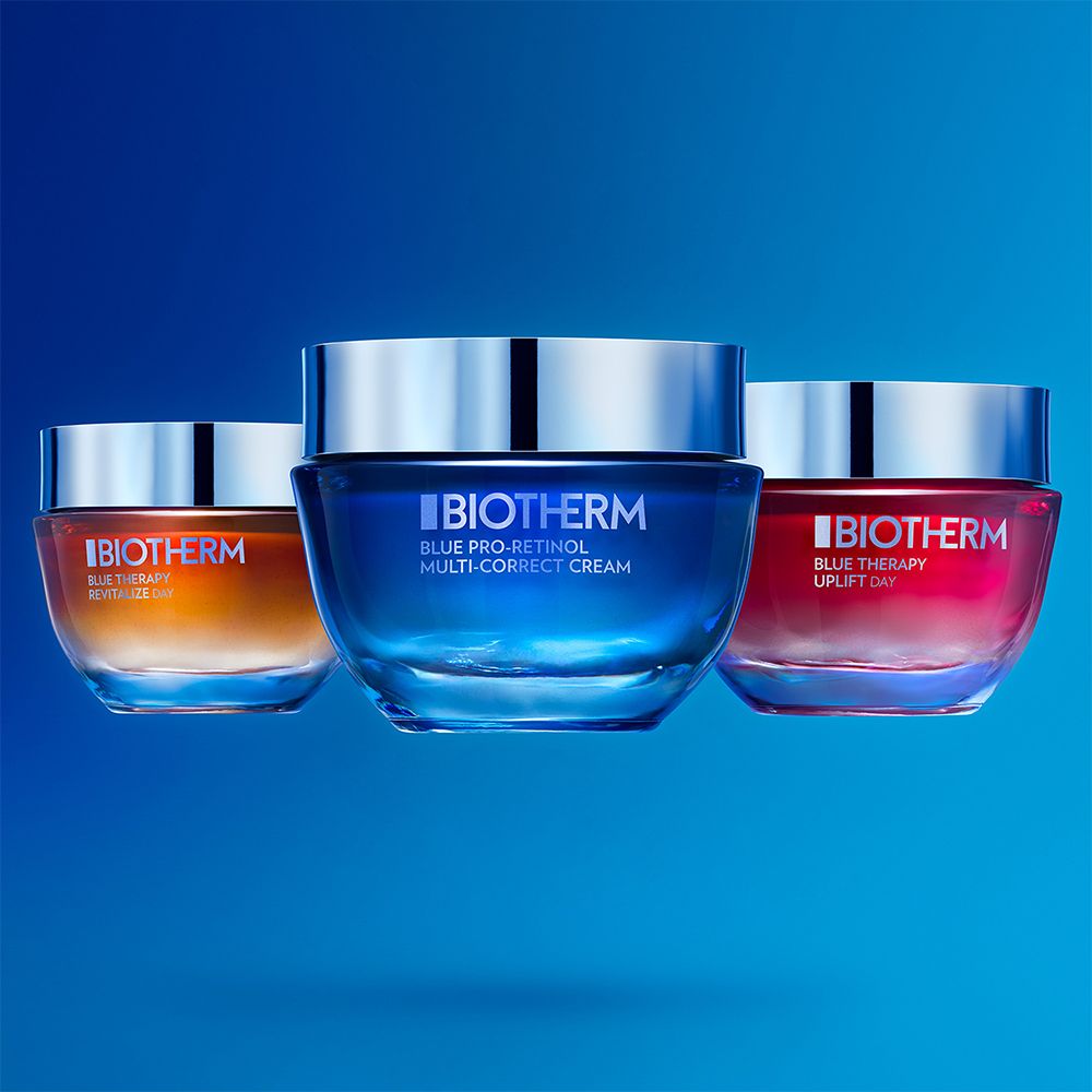 Trois pots Biotherm : jaune, bleu et rose, avec couvercles argentés.