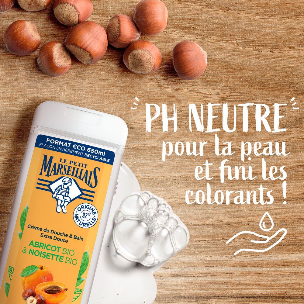 Flacon et mousse. Texte: pH neutre pour la peau. Le Petit Marseillais Crème de Douche & Bain. Abricot BIO & Noisette BIO.