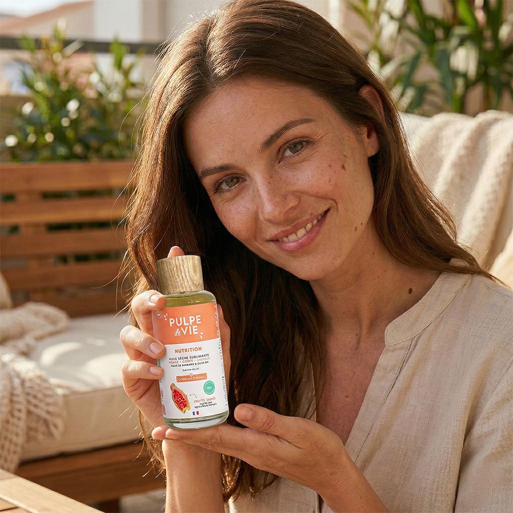 Femme tenant un flacon. Inscription: PULPE de VIE, Nutrition. Bouchon en bois. Femme souriante.