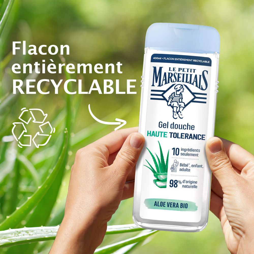Mains tenant un flacon. Texte: Le Petit Marseillais, Gel douche Haute Tolérance. Flacon recyclable.