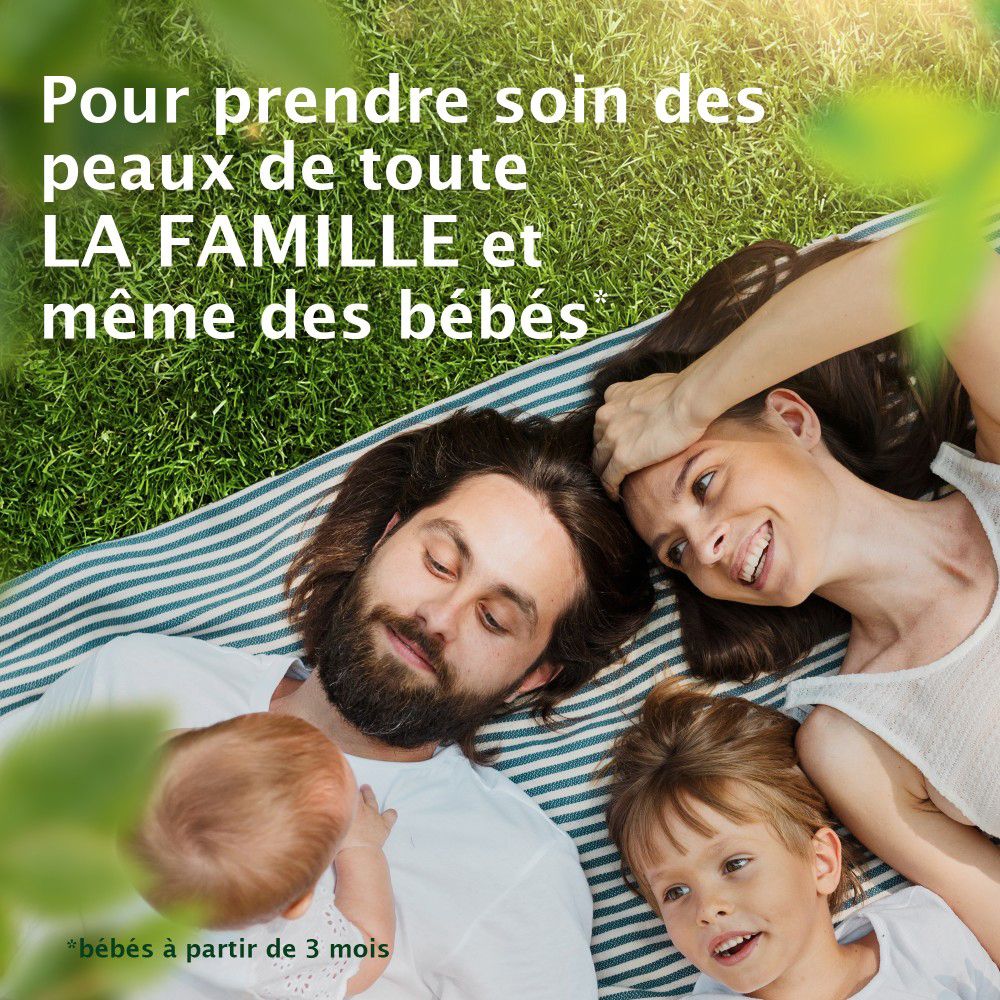 Famille allongée sur une couverture dans l'herbe. Texte: Pour la peau de toute la famille et des bébés.