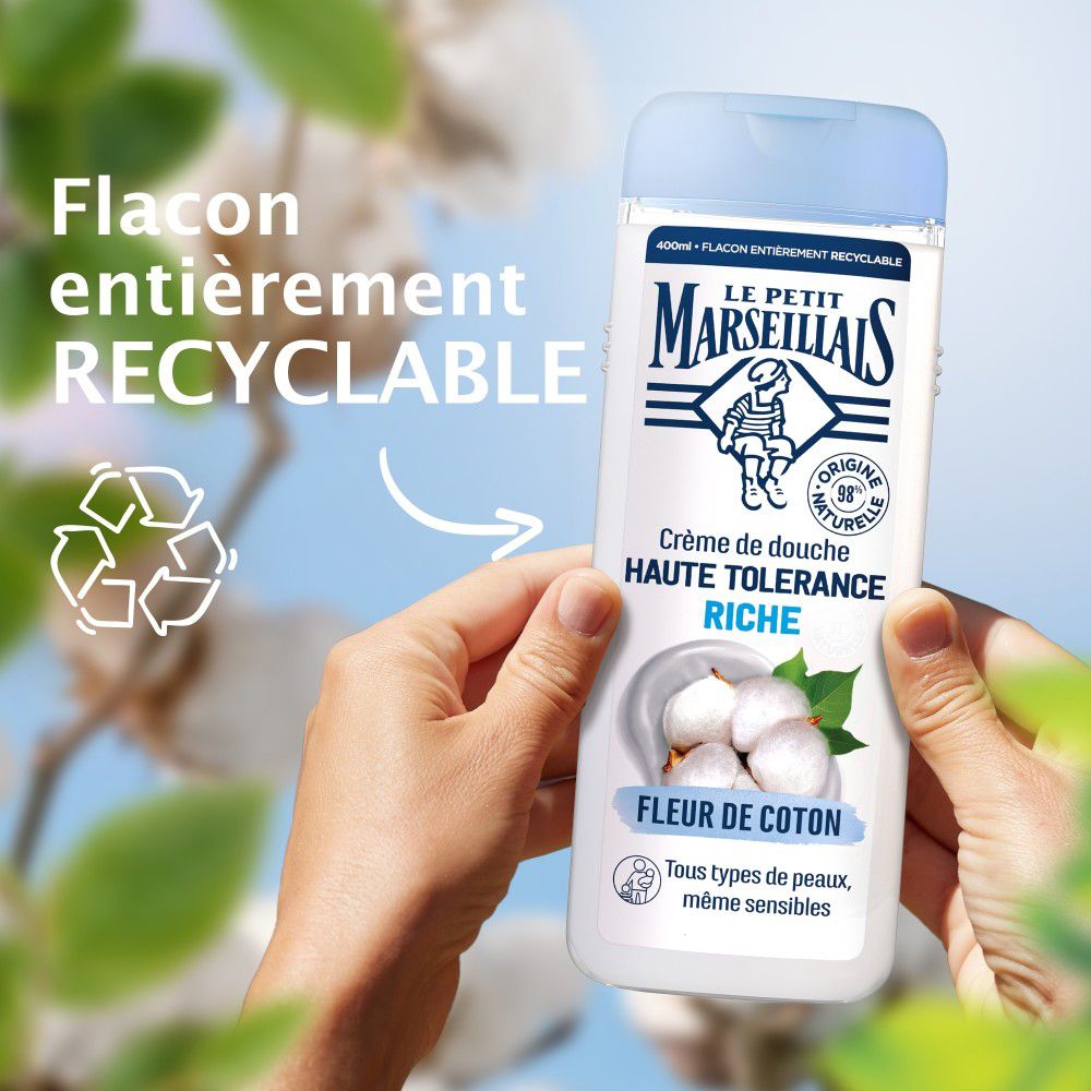 Mains tenant un flacon de crème de douche. Flacon recyclable.