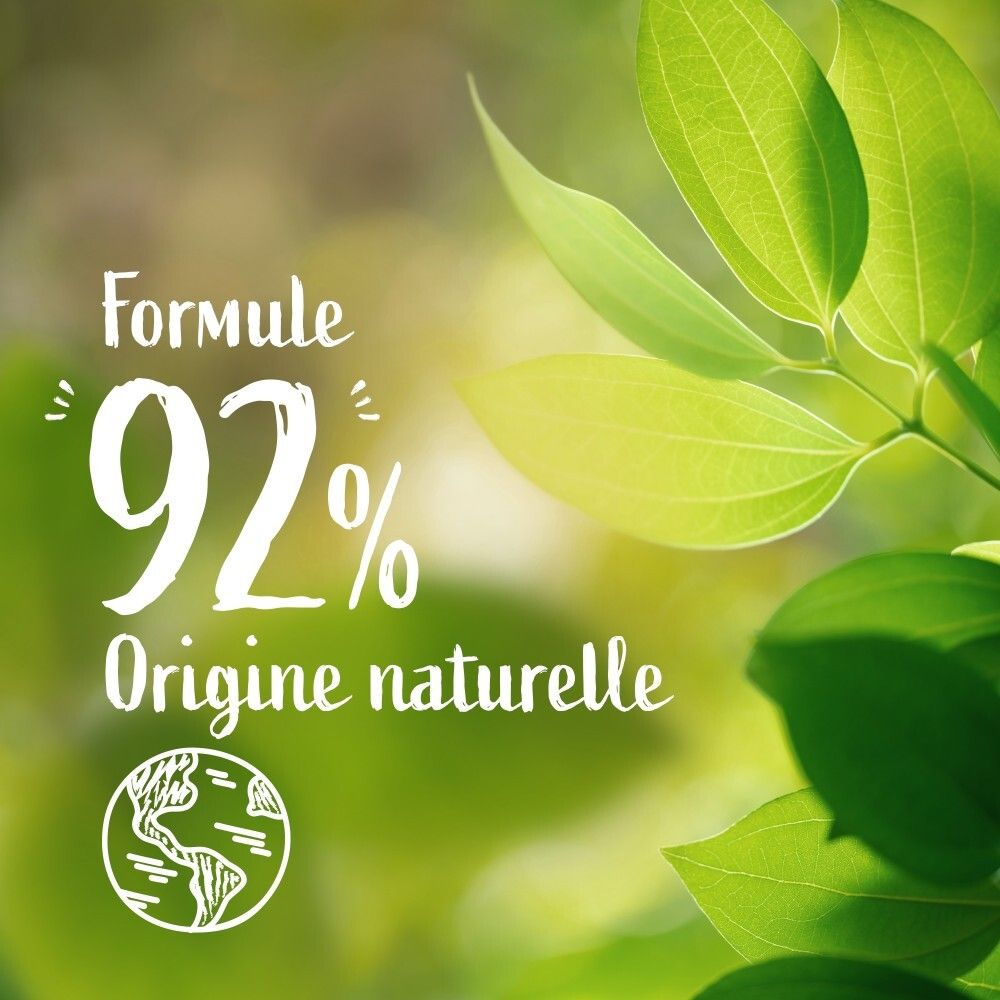 Gros plan sur des feuilles vertes avec le texte "Formule 92% Origine naturelle".