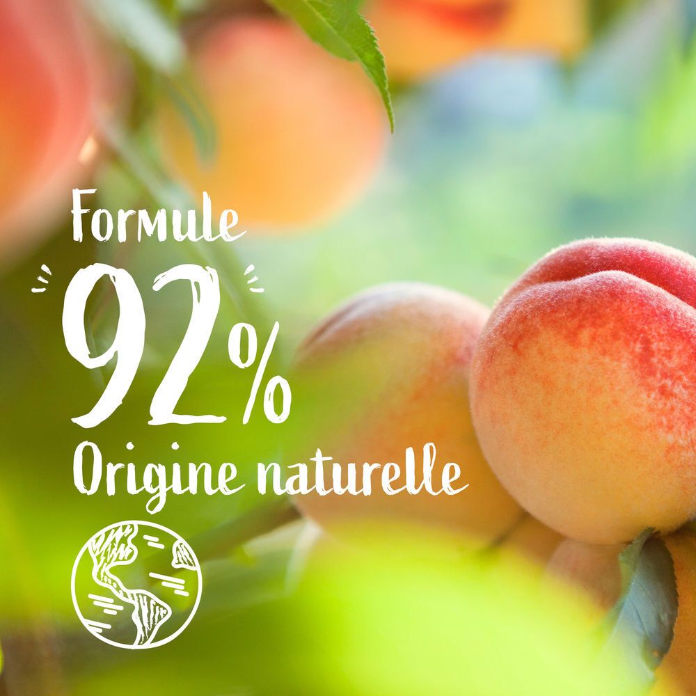 Gros plan de pêches sur une branche avec l'inscription 'Formule 92% Origine naturelle'.