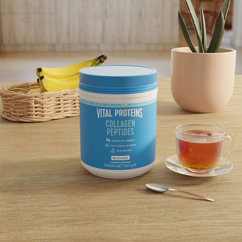Un contenant bleu de Vital Proteins Collagen Peptides sur une table en bois, près d'une tasse de thé et de bananes.