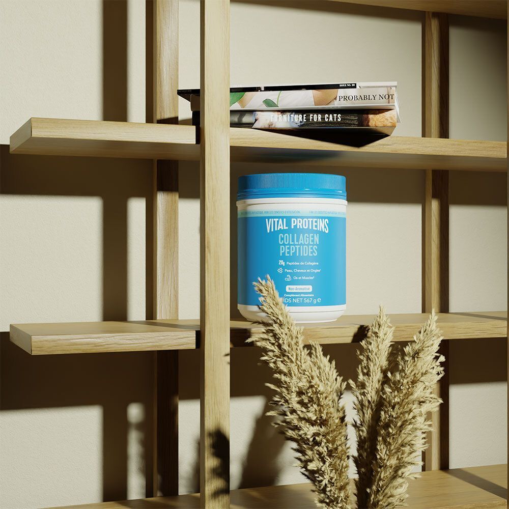Un contenant bleu de Vital Proteins Collagen Peptides sur une étagère, entre des livres et des plantes.