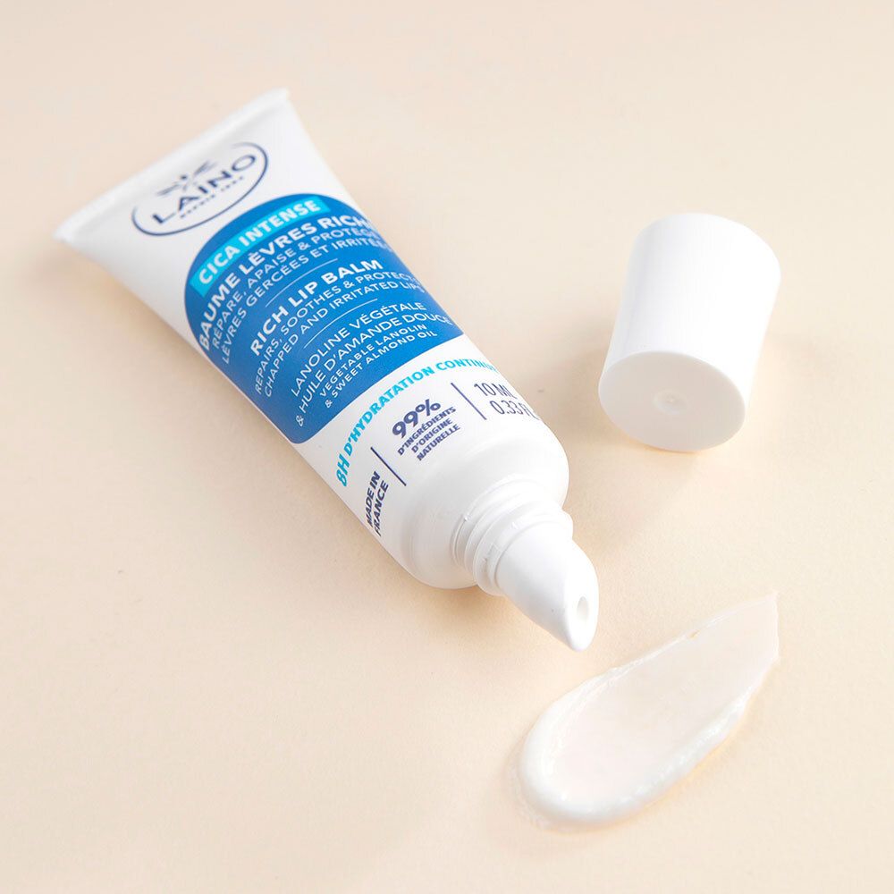 Tube de baume à lèvres Laino Cica Intense et produit. Tube ouvert, baume visible. Blanc, bleu et beige clair.