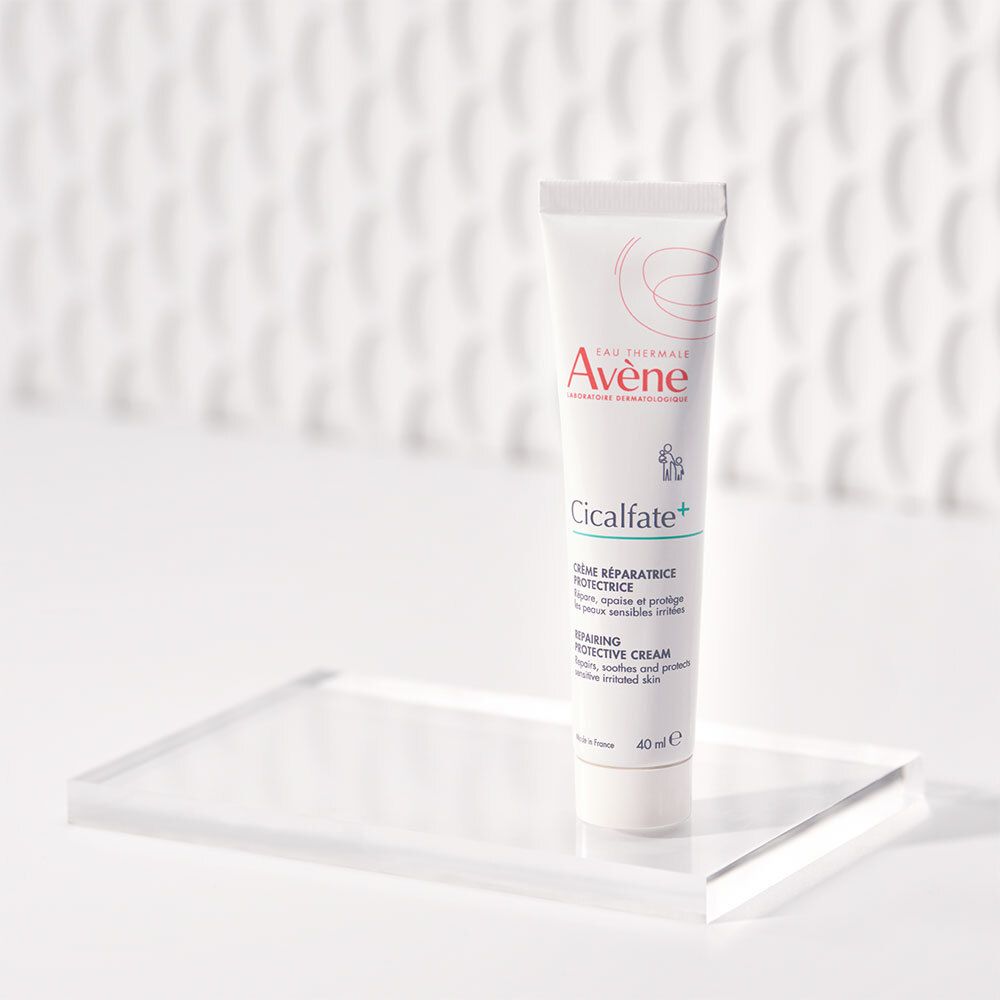 Un tube de crème sur un présentoir transparent. Inscription: Eau Thermale Avène, Cicalfate+, Crème réparatrice protectrice, Repairing Protective Cream, 40 ml.