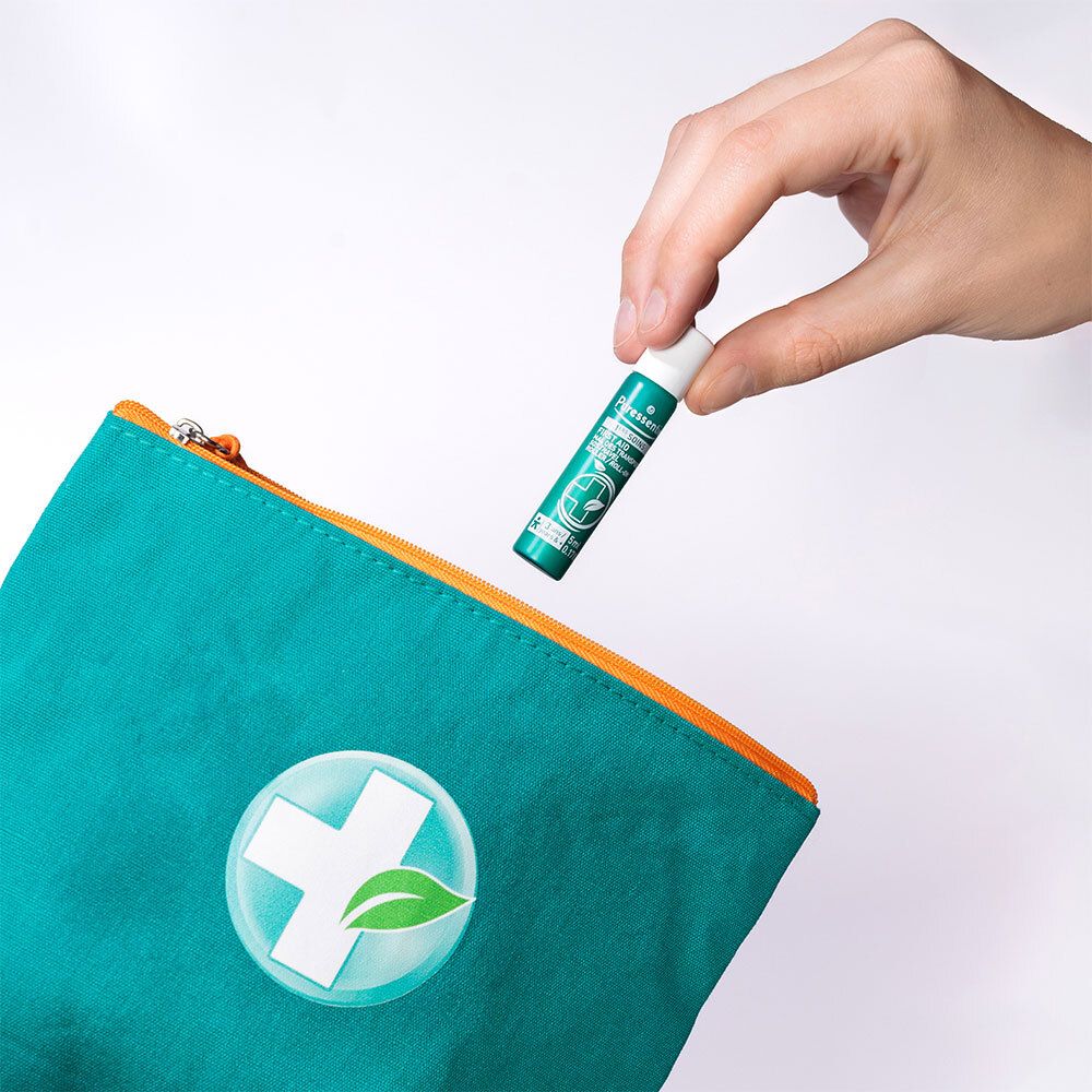 Main utilisant le Puressentiel Roller Mal des Transports, 5ml, sorti d'une trousse.