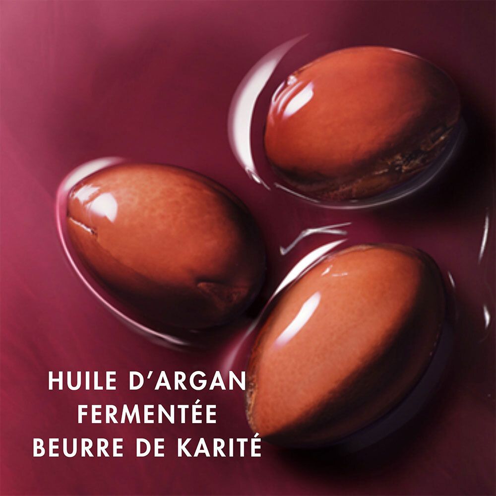 Trois graines d'argan brunes dans un liquide. Texte : Huile d'Argan fermentée, Beurre de Karité.