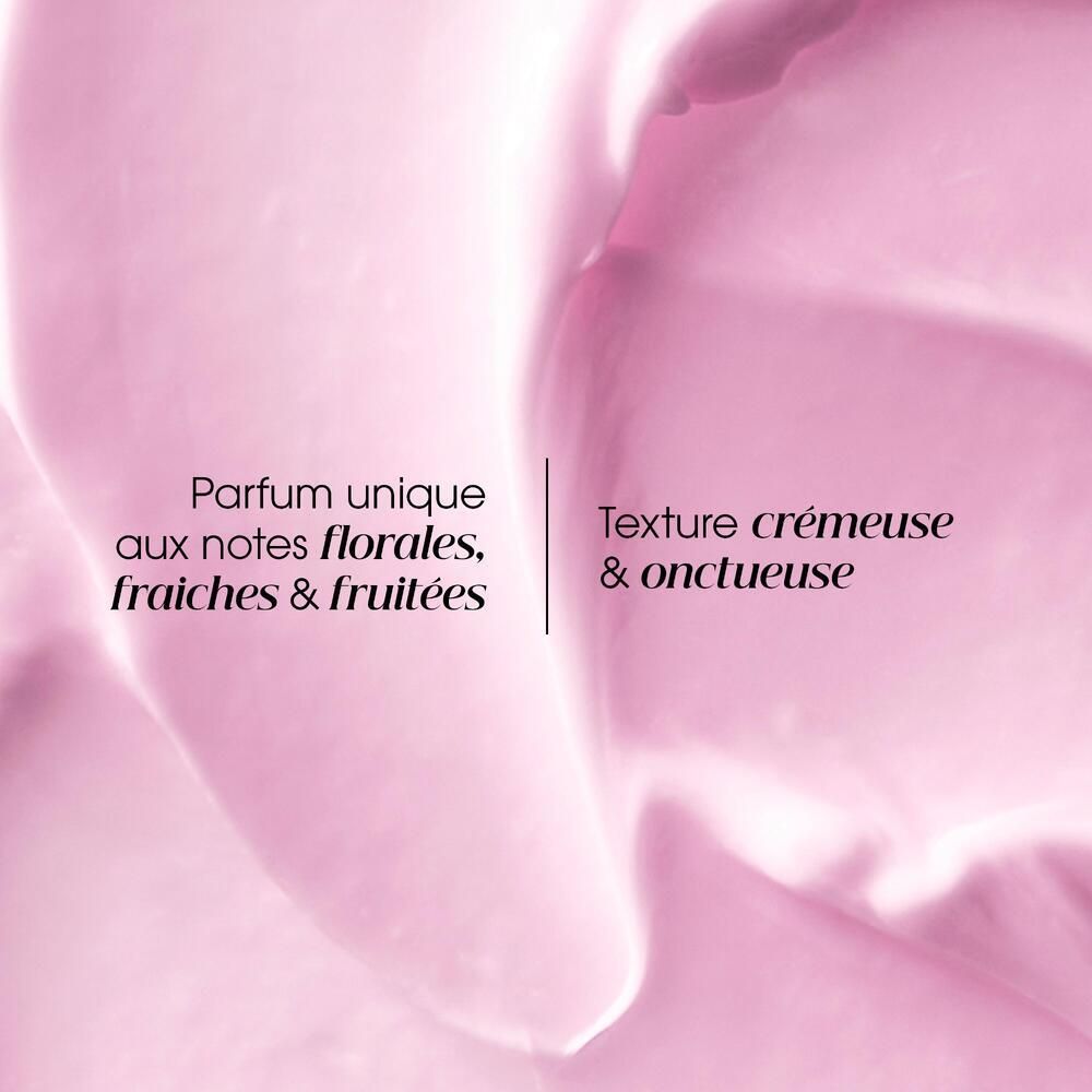 Gros plan sur une texture crémeuse rose. Texte: Parfum unique aux notes florales, fraîches & fruitées. Texture crémeuse & onctueuse.