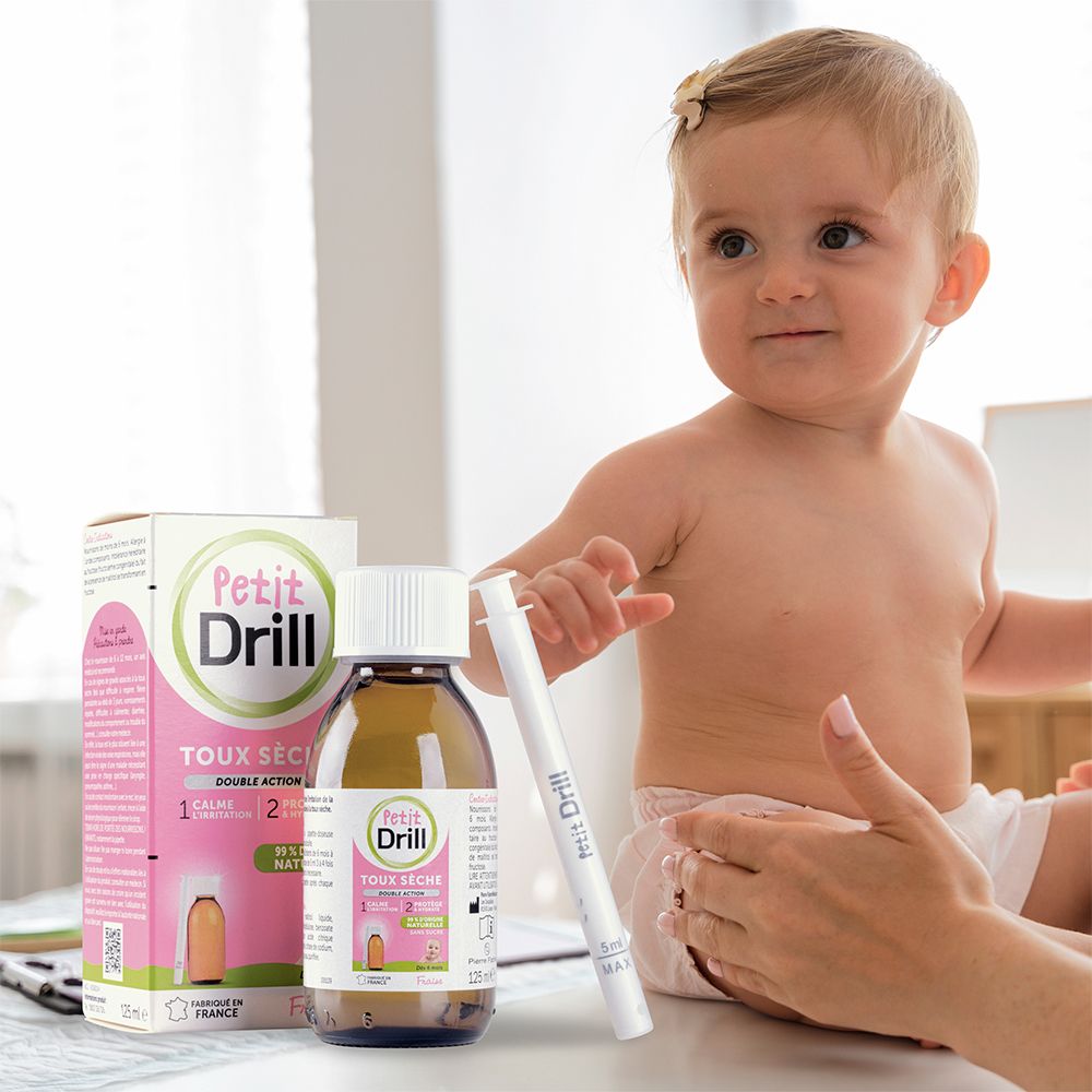 Bébé avec flacon et pipette. Boîte Petit Drill en arrière-plan. Bébé assis.