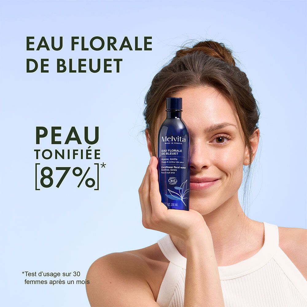 Femme tenant une bouteille d'eau florale de bleuet Melvita devant son visage. Texte sur le tonus de la peau.