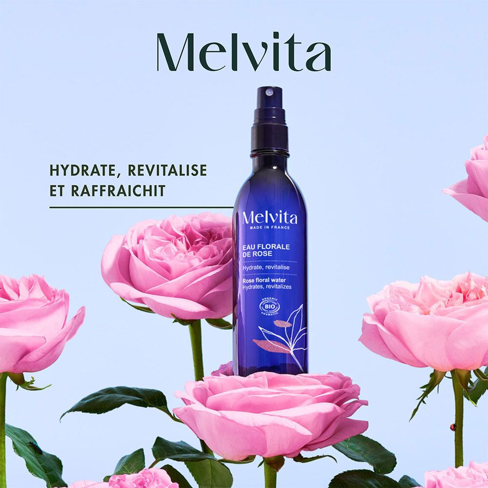 Flacon bleu transparent avec vaporisateur, entouré de roses roses. Inscription: Melvita, Eau Florale de Rose. Certification bio.