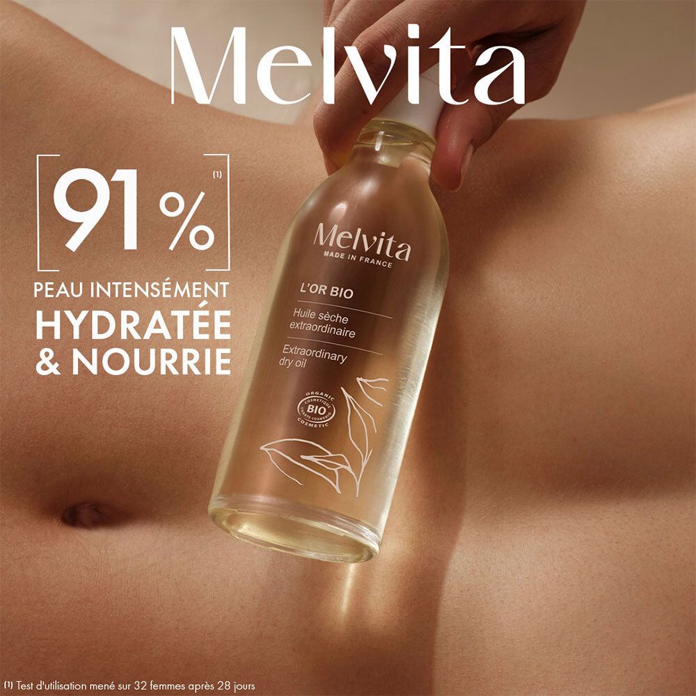 Flacon d'huile Melvita L'Or Bio. Main tenant le flacon sur la peau. Texte: 91% hydratée & nourrie.