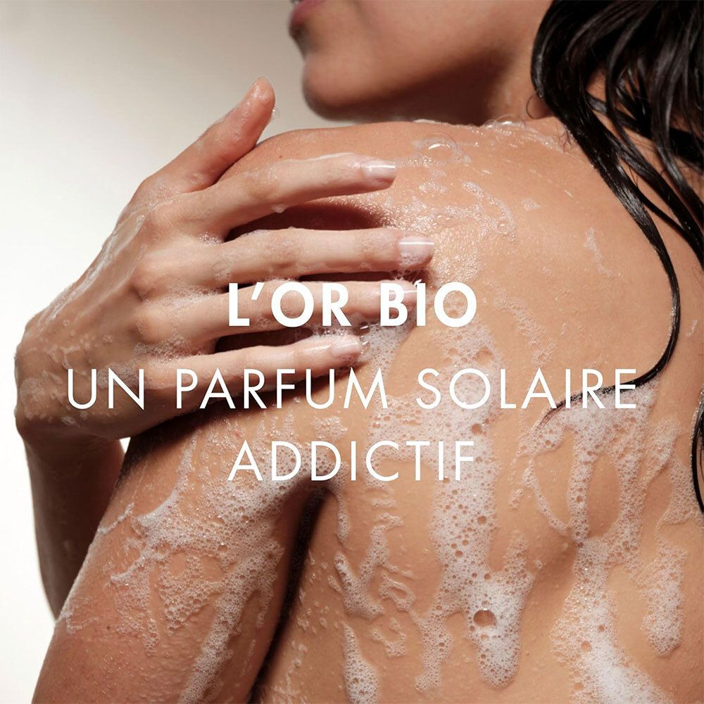 Dos d'une personne avec de la mousse. Texte: L'Or Bio, Un parfum solaire addictif.