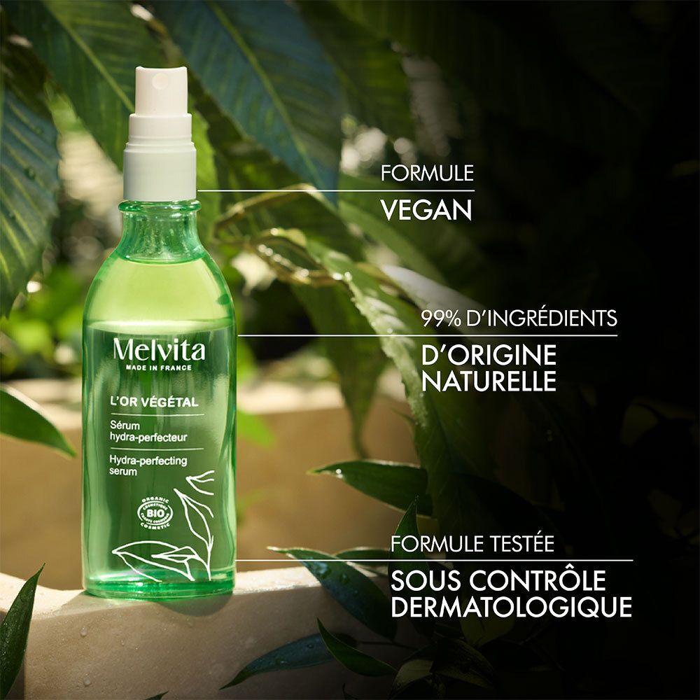 Flacon de sérum devant des feuilles. Texte : Formule vegan. 99% ingrédients naturels. Testé dermatologiquement.