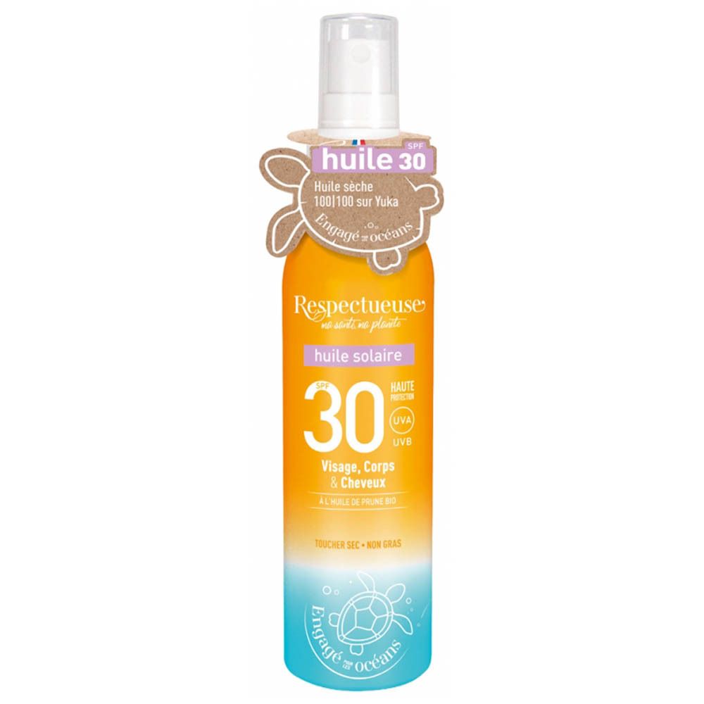 Flacon spray d'huile solaire. Étiquette orange et bleue avec SPF 30. Texte : Respectueuse, huile solaire, Visage, Corps & Cheveux. Logo tortue.