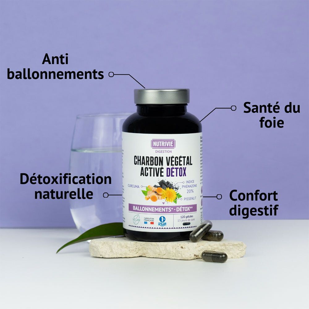 Flacon NUTRIVIE CHARBON VÉGÉTAL ACTIVE DÉTOX avec étiquette, carafe en verre et capsules à côté.