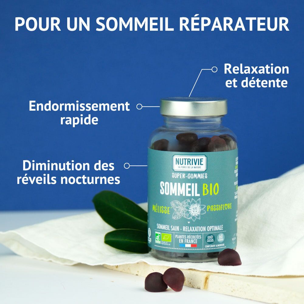 Nutrivie Sommeil Bio Gummies : flacon en verre avec gummies foncés, entouré de feuilles et de gummies individuels.