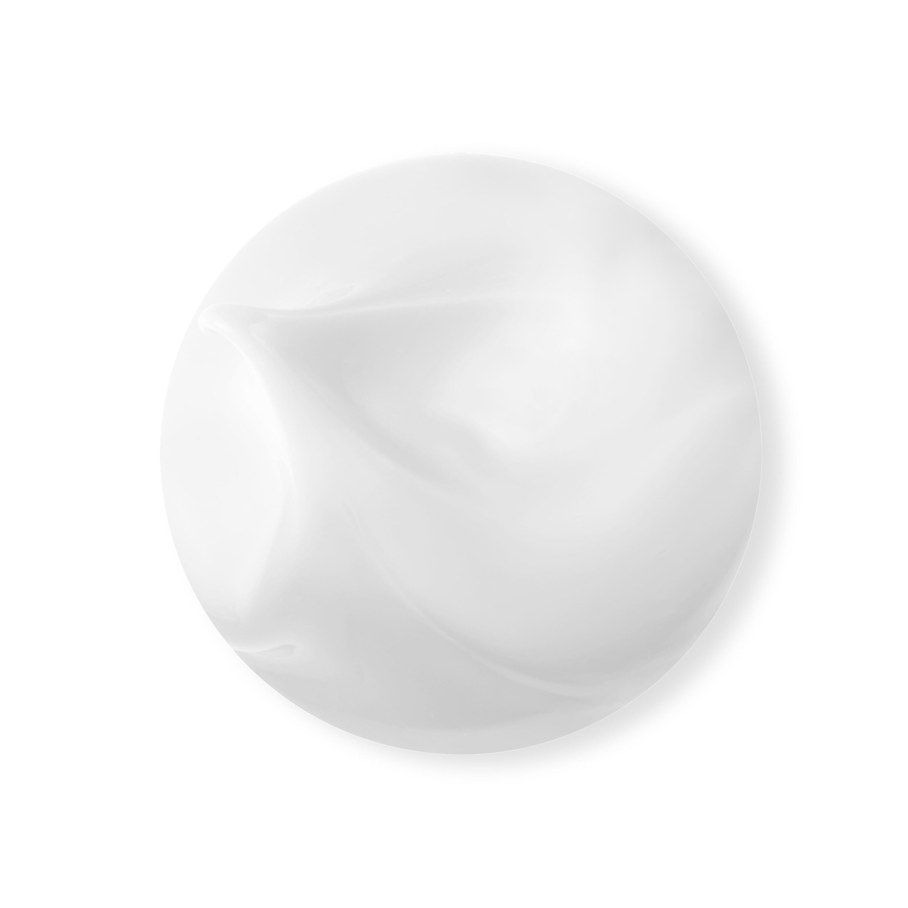 Gros plan d'une crème blanche. Forme ronde, surface lisse. Légère dépression.