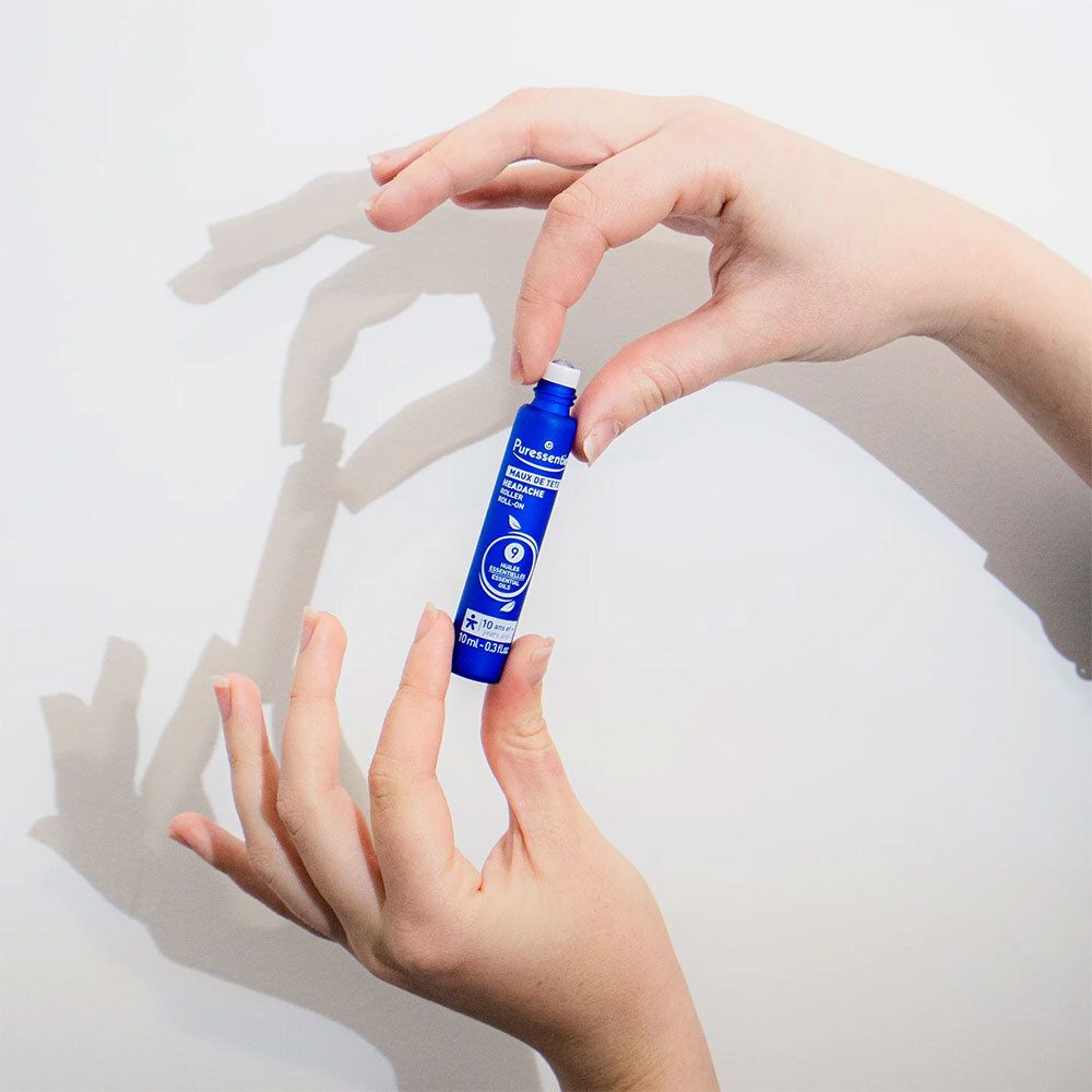 Mains tenant un roll-on bleu. Fond blanc.
