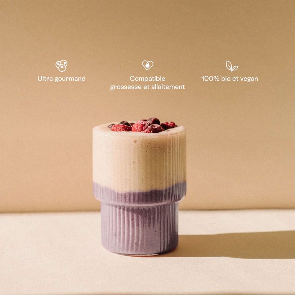 Smoothie bicolore dans un verre cannelé, garni de baies. Texte: Ultra gourmand, compatible grossesse, bio et vegan.