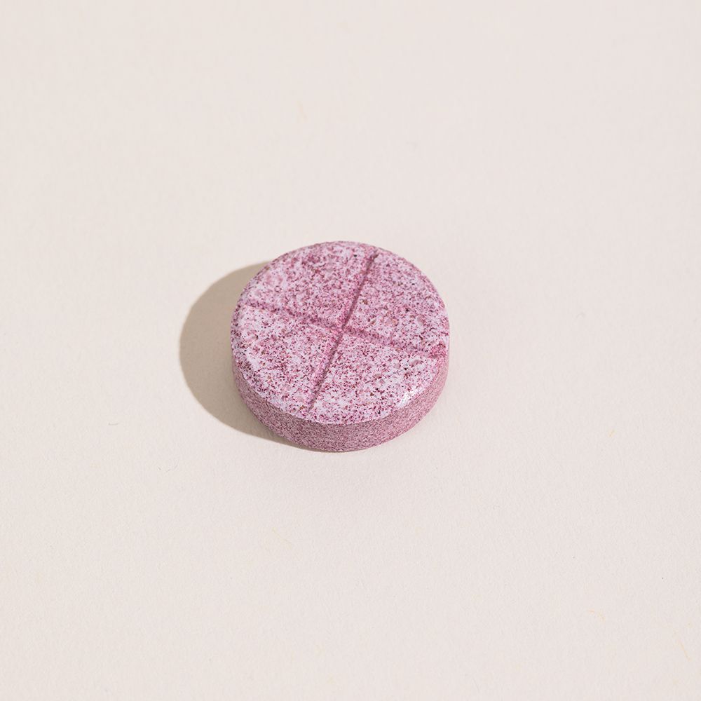 Comprimé rose unique. Lignes croisées sur la surface.