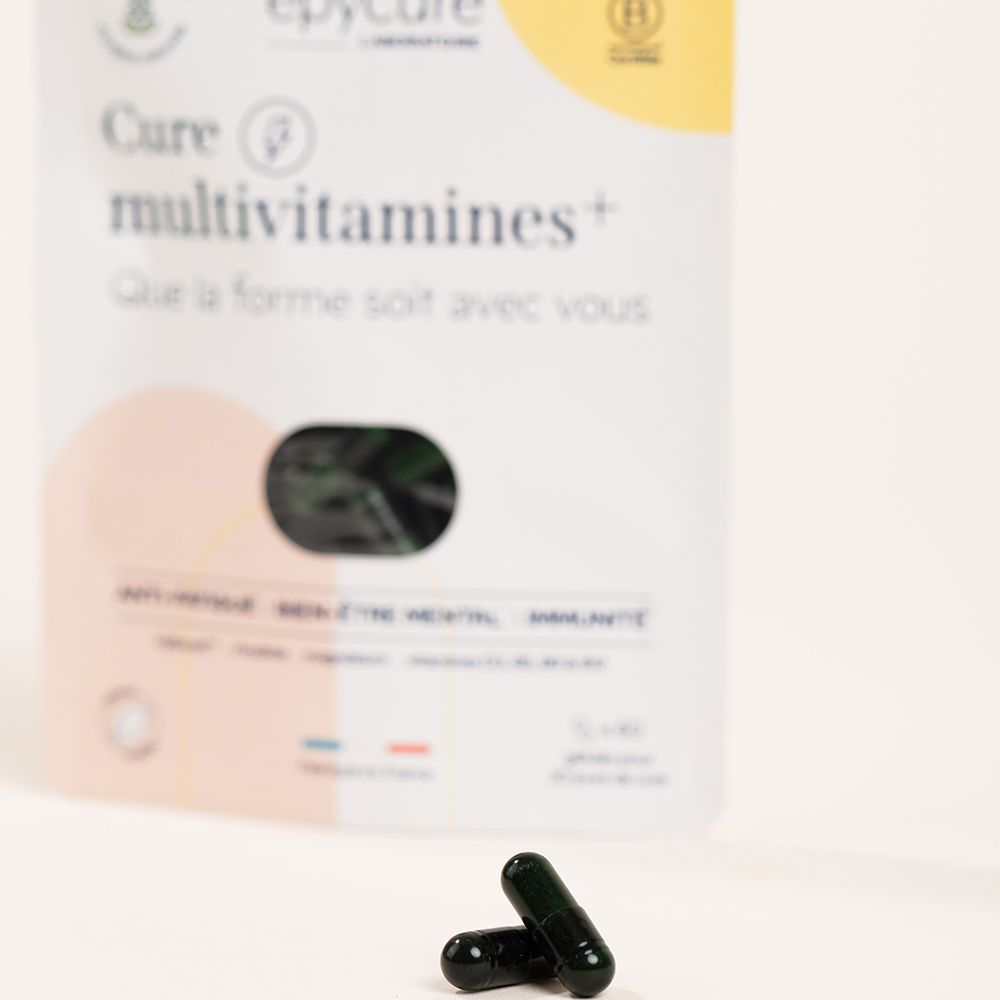 Deux gélules noires. Fond: sachet Cure multivitamines+. Inscription: epycure, certification B.