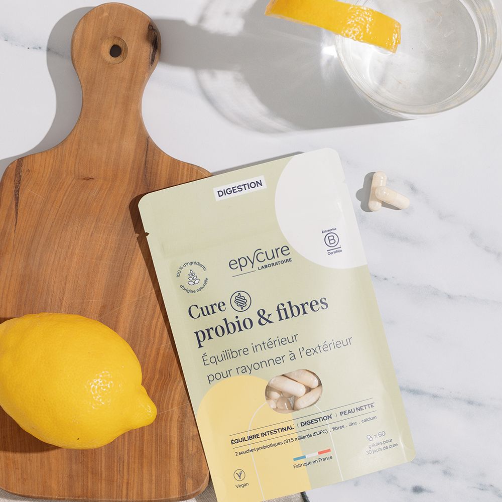 Emballage du produit, citron, planche de bois et verre d'eau. Epycure Probio & Fibre Complex gélules. Texte: Cure probio & fibres.