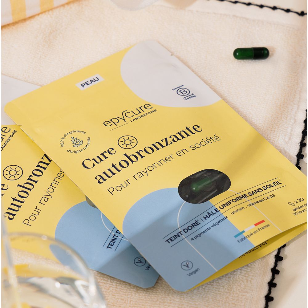 Deux sachets jaunes avec Cure autobronzante, une gélule, un verre d'eau.