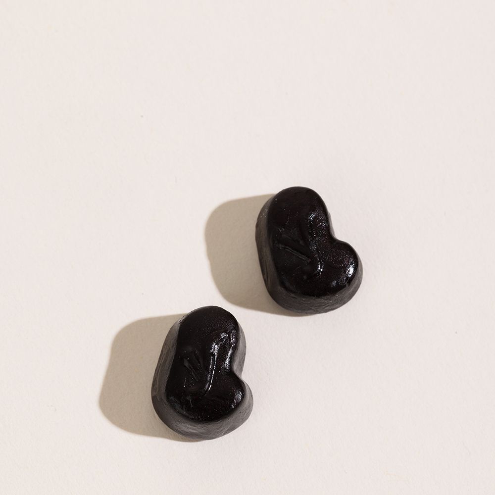 Deux gommes noires en forme de cœur sur fond blanc.